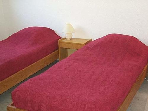 2 camas con colchas rojas en una habitación en Appartement La Grande-Motte, 2 pièces, 5 personnes - FR-1-328-223, en La Grande-Motte