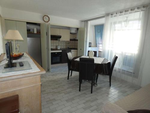 une cuisine et une salle à manger avec une table et des chaises dans l'établissement Bel appartement 2 pièces avec loggia vitrée, au calme, proche plage et commerces, parking inclus - FR-1-328-237, à La Grande Motte