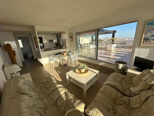 un salon avec un canapé et une grande fenêtre dans l'établissement Superbe 3 pièces avec terrasse près de la plage et commerces, parking inclus - FR-1-328-233, à La Grande Motte