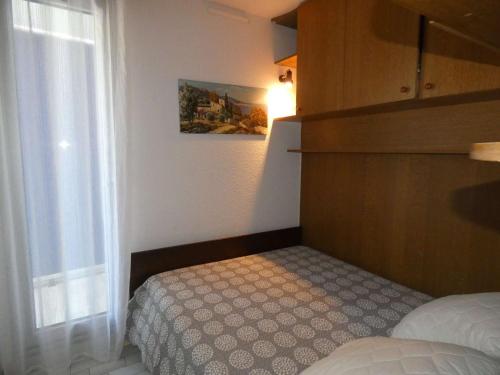une petite chambre avec un lit et une fenêtre dans l'établissement Bel appartement 2 pièces avec loggia vitrée, au calme, proche plage et commerces, parking inclus - FR-1-328-237, à La Grande Motte