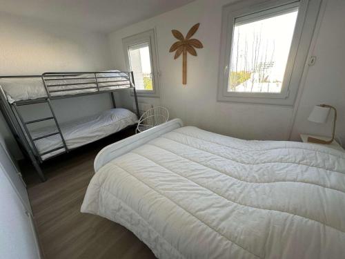 une chambre avec deux lits superposés et une fenêtre dans l'établissement Superbe 3 pièces avec terrasse près de la plage et commerces, parking inclus - FR-1-328-233, à La Grande Motte