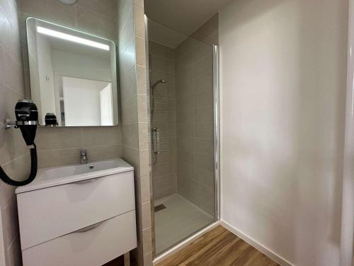une salle de bain avec une douche, un lavabo et un miroir dans l'établissement Appartement Climatisé, Proche Plage et Commerces, 4 Pers., Parking Privé, Quartier du Couchant - FR-1-328-235, à La Grande Motte