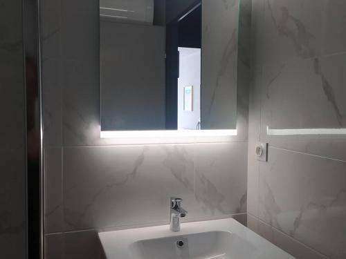 een witte badkamer met een wastafel en een spiegel bij Studio La Grande-Motte, 1 pièce, 4 personnes - FR-1-328-247 in La Grande-Motte