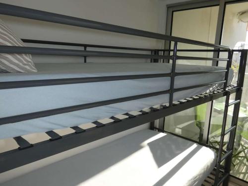 - une pile de lits superposés dans une chambre dans l'établissement Studio Cabine Moderne, 100m de la Plage, Parking et Wifi Inclus - FR-1-328-253, à La Grande Motte