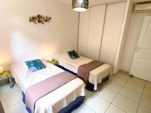 um quarto com duas camas num quarto em Appartement Les Trois-Ilets, 3 pièces, 4 personnes - FR-1-765-22 em Les Trois-Îlets