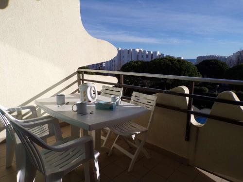 une table et des chaises assises sur un balcon dans l'établissement Studio cabine avec piscine, proche plage et commerces - FR-1-328-263, à La Grande Motte