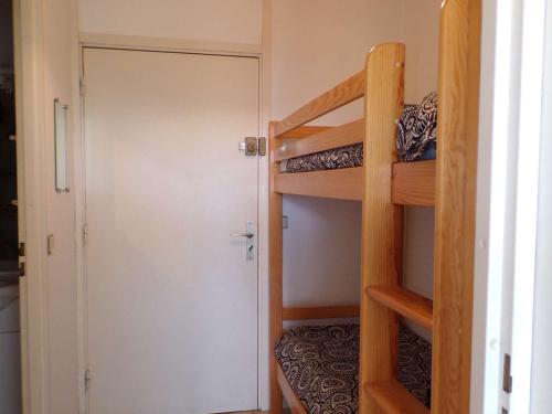 Cette petite chambre comprend 2 lits superposés et une porte. dans l'établissement Studio cabine avec piscine, proche plage et commerces - FR-1-328-263, à La Grande Motte