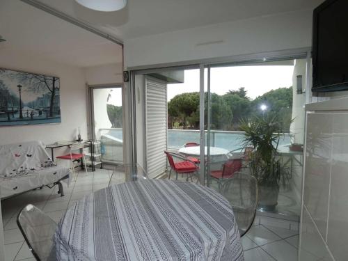 Cette chambre dispose d'une table, de chaises et d'un balcon. dans l'établissement Appartement 2 pièces avec piscine, parking privé, proche commerces et plage, exposé sud - FR-1-328-264, à La Grande Motte