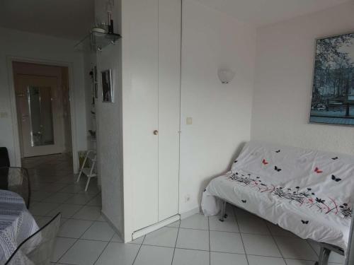 une chambre avec un lit et un mur blanc dans l'établissement Appartement 2 pièces avec piscine, parking privé, proche commerces et plage, exposé sud - FR-1-328-264, à La Grande Motte