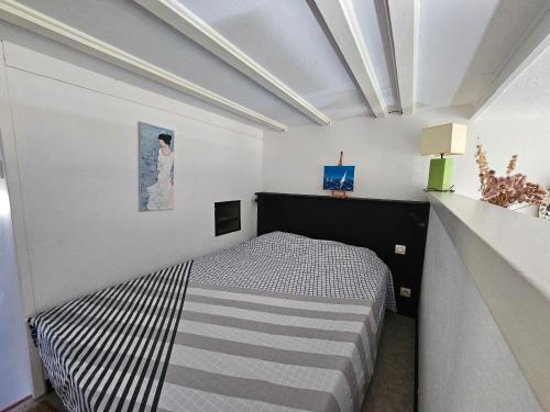 une chambre avec un lit dans une pièce blanche dans l'établissement Charmant T2 à Saint-Cyprien - Terrasse, Clim, Proche Plage et Parking Privé - FR-1-309-444, à Saint-Cyprien
