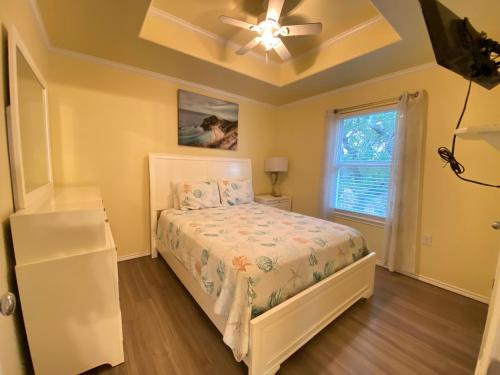 une chambre avec un lit et un ventilateur de plafond dans l'établissement Horizon Cottage #5, à Rockport