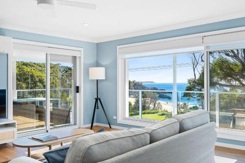 a living room with a couch and large windows at 198 Mystery Bay Road, Mystery Bay in Mystery Bay