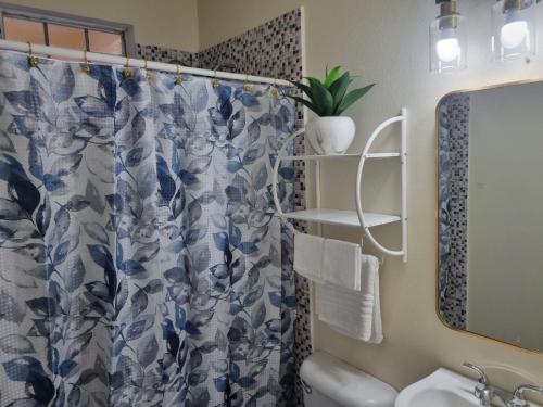 uma casa de banho com uma cortina de chuveiro azul e branco em A&A Air Bed and Breakfast em Vernons