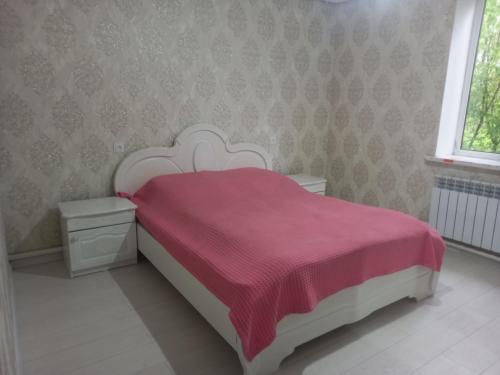 a bedroom with a white bed with a red blanket at Zholaman in Kerben