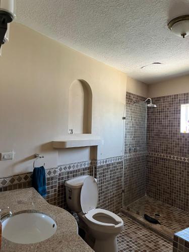 a bathroom with a toilet and a sink and a shower at Casa Huesped San Marcos in Ciudad Juárez