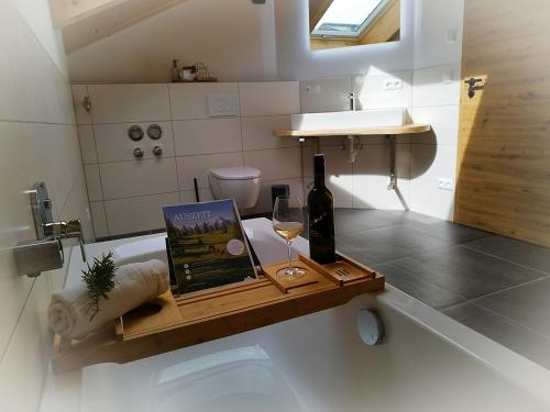 eine Flasche Wein und ein Buch auf dem Tisch im Bad in der Unterkunft FeWos Franz Hofreiter in Schönau am Königssee