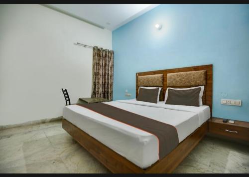 um quarto com uma cama grande e paredes azuis em Hotel deep bell hotel em Chandīgarh