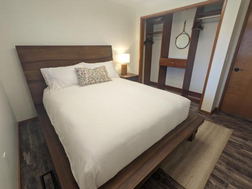 a bedroom with a large white bed with a wooden headboard at Cozy Place for Family and Friends in Dundee