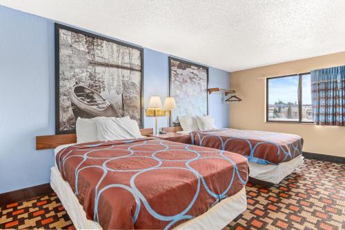 2 łóżka w pokoju z niebieskimi ścianami w obiekcie StayInn Little Falls w mieście Little Falls