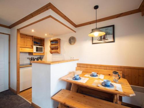 une cuisine avec une table en bois et un comptoir dans l'établissement Appartement cosy avec 2 balcons, casier à skis et services inclus, Valmorel - FR-1-291-1007, à Valmorel