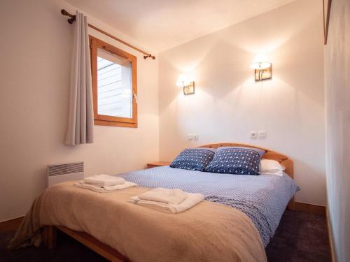 une chambre avec un lit avec deux serviettes dessus dans l'établissement Appartement cosy avec 2 balcons, casier à skis et services inclus, Valmorel - FR-1-291-1007, à Valmorel