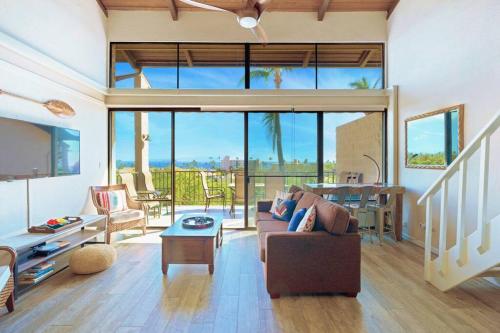 a living room with a couch and a table at 3BR Penthouse- ocean views, lanais, ACs, hot tub, pool, sauna, steps to beach in Kihei