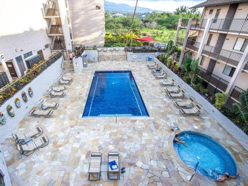 an overhead view of a swimming pool with lounge chairs and a swimming pool at 3BR Penthouse- ocean views, lanais, ACs, hot tub, pool, sauna, steps to beach in Kihei