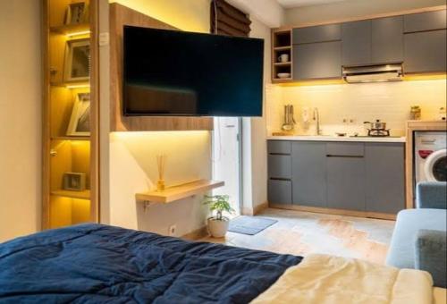 Il comprend une chambre avec un lit et une cuisine avec une télévision. dans l'établissement Cerah Sentosa, à Sibolga