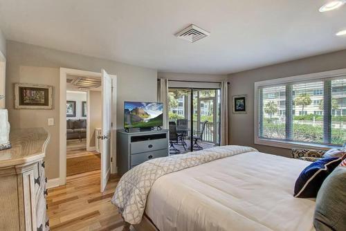棕櫚島的住宿－Port O'Call C102 by Wild Dunes, Ocean View Condo with Resort Amenity Access，一间卧室配有一张大床和电视
