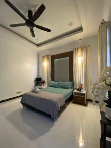 Schlafzimmer mit einem Bett und einem Deckenventilator in der Unterkunft Safa Homestay Kuala Terengganu in Kuala Terengganu