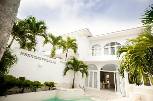 een wit huis met palmbomen en een zwembad bij La Playa, Bali in Munggu