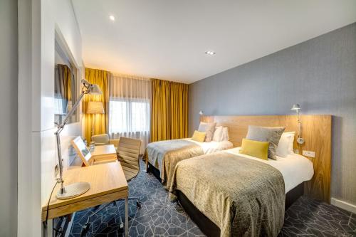 a hotel room with two beds and a desk at Apex City of Glasgow Hotel in Glasgow