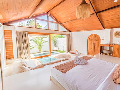 a bedroom with a large bed and a large window at BaraJade Villas in Uluwatu