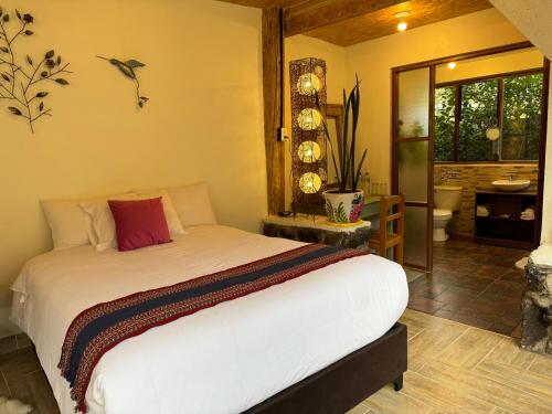 a bedroom with a bed and a bathroom at Spirit Of The River Lodge in Cusco