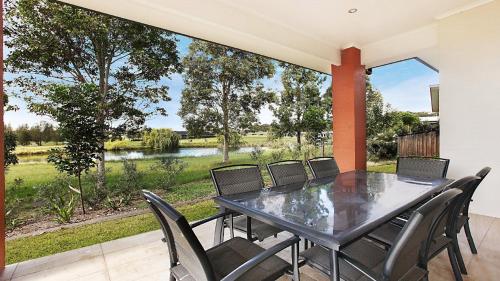 a dining room with a table and chairs and a large window at Amber Lakes - The Vintage in Pokolbin
