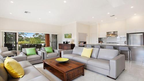 a living room with a couch and a table at Amber Lakes - The Vintage in Pokolbin