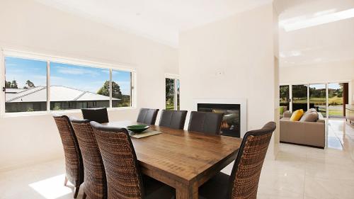 a dining room with a wooden table and chairs at Amber Lakes - The Vintage in Pokolbin