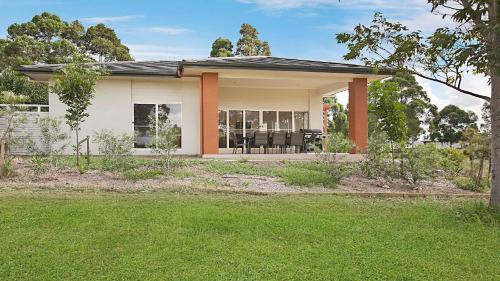 a house with a porch and a lawn at Amber Lakes - The Vintage in Pokolbin
