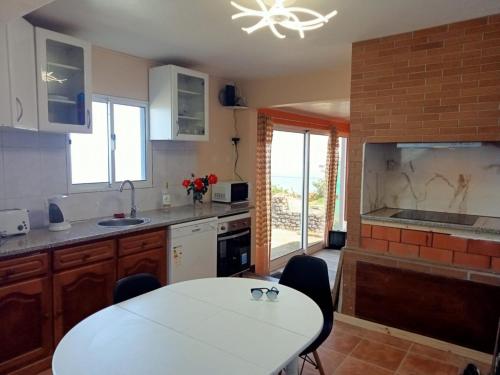 a kitchen with a table and a white counter top at Lombada Villa Comfort in Ponta Delgada
