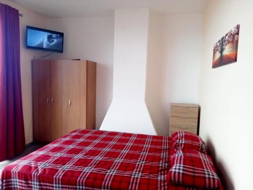 um quarto com um cobertor xadrez vermelho numa cama em Lombada Villa Comfort em Ponta Delgada