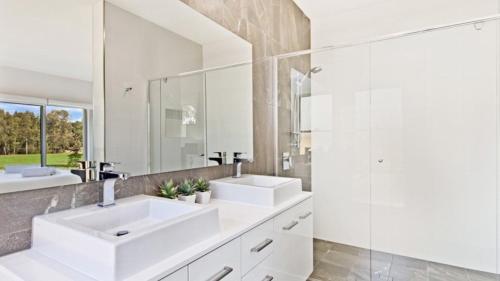a white bathroom with two sinks and a mirror at Santa Ana Retreat - The Vintage in Pokolbin