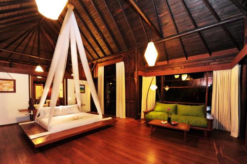 a room with a bed and a couch in a room at Villa Inle Boutique Resort in Nyaung Shwe