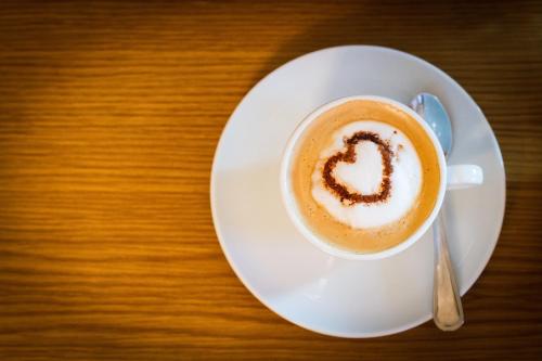 a cup of coffee with a heart drawn on top at Boutique-Hotel Alter Gerichtshof in Hartberg
