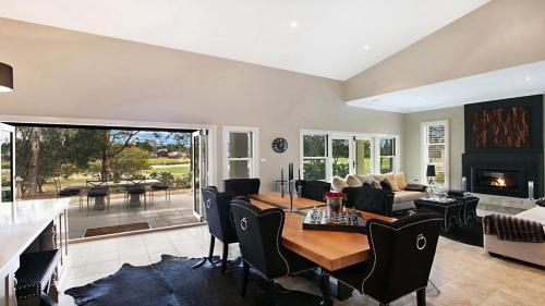 a living room with a table and a couch and a fireplace at The Vintage Manor in Pokolbin