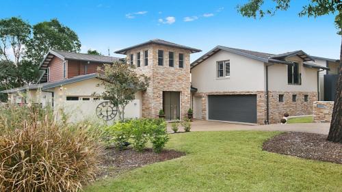 a large white house with a garage at The Vintage Manor in Pokolbin