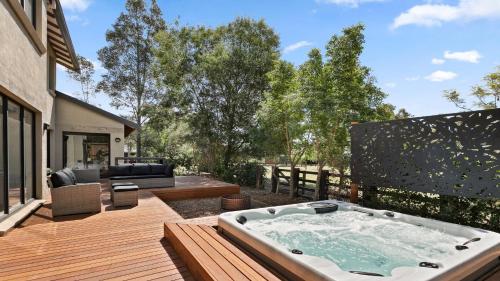 a hot tub on the deck of a house at Wine Down in Pokolbin