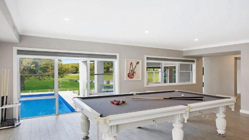 a pool table in a room with a swimming pool at Chateau Caliza in Pokolbin