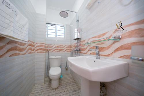 a bathroom with a sink and a toilet at Résidence Vinelly in Douala