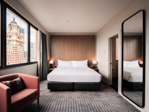 a hotel room with a bed and a chair at DoubleTree by Hilton Melbourne in Melbourne