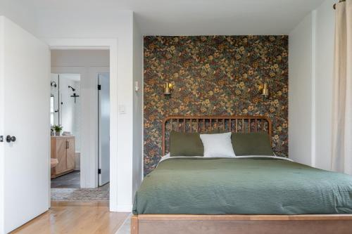 ein Schlafzimmer mit einem grünen Bett mit Blumentapete in der Unterkunft Charcoal Chalet by AvantStay A Design w Firepit in New Paltz